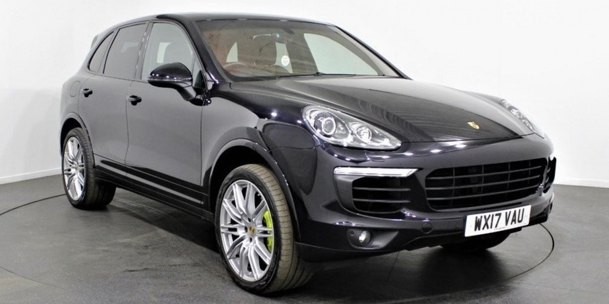 Black Porsche Cayenne parked three-quarters facing right